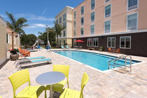 a pool with chairs and a table and a table and chairs at Home2 Suites By Hilton Nokomis in Nokomis