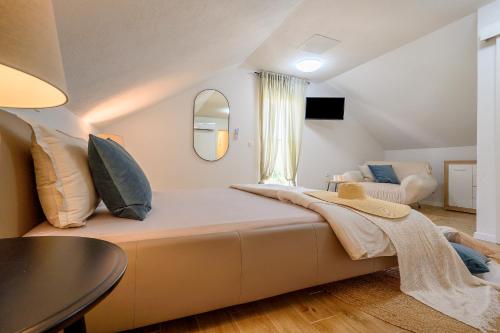 een slaapkamer met een groot bed en een spiegel bij Villa Bellezza in Milna