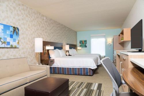 une chambre d'hôtel avec un lit et un canapé dans l'établissement Home2 Suites By Hilton Nokomis, à Nokomis