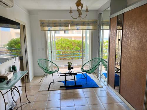 een woonkamer met stoelen en een tafel en een balkon bij Cool Appart sur Croisette Palm Beach in Cannes