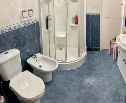 y baño con aseo, ducha y lavamanos. en Vivienda en Combarro, en Combarro