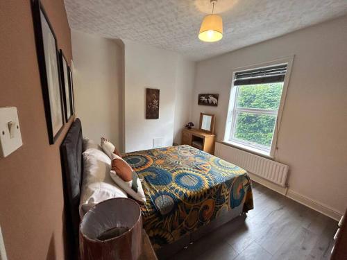 um quarto com uma cama e uma janela em Spacious homely 3 bed property em Newcastle under Lyme