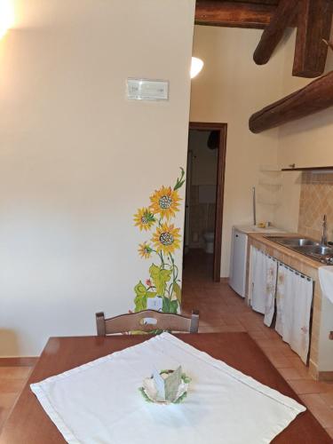 Agriturismo la Torre في بينابيلي: مطبخ مع طاولة مع وردة على الحائط