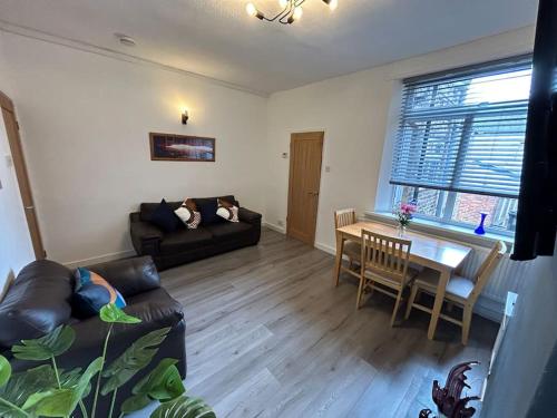 a living room with a couch and a table at Spacious homely 3 bed property in Newcastle under Lyme