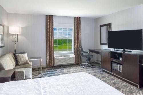 a hotel room with a bed and a flat screen tv at Hampton Inn & Suites Bridgewater, NJ in Bridgewater