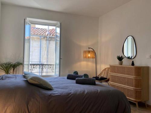 une chambre avec un grand lit avec une grande fenêtre dans l'établissement Appartement rénové plein centre d'Avignon, à Avignon