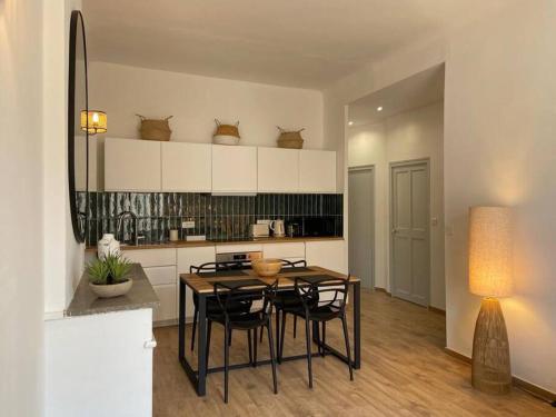 une cuisine avec une table et des chaises dans une pièce dans l'établissement Appartement rénové plein centre d'Avignon, à Avignon