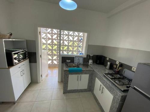une cuisine avec une cuisinière et un comptoir dans l'établissement Appartement avec piscine Imi ouaddar - Family only, à Agadir