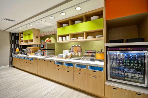 a restaurant with a counter with a drink cooler at Home2 Suites By Hilton Livermore in Livermore
