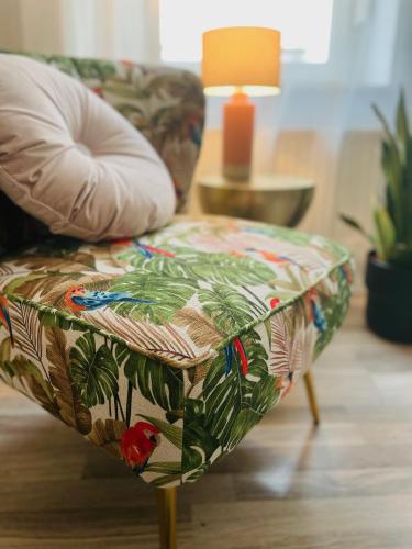Un sofá con un asiento con estampado tropical. en Apartment Boho Living, en Bautzen