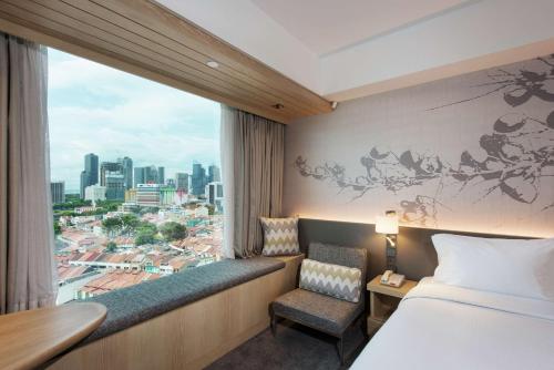 Hilton Garden Inn Singapore Serangoon في سنغافورة: غرفه فندقيه بسرير ونافذه