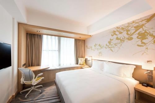 a hotel room with a large bed and a desk at Hilton Garden Inn Singapore Serangoon in Singapore