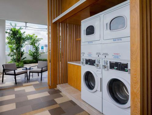 a laundry room with a washer and dryer at Hilton Garden Inn Singapore Serangoon in Singapore