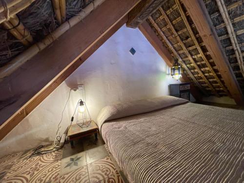 a bedroom with a large bed in an attic at Chozito de paja a 300m. playa Mangueta in El Palmar