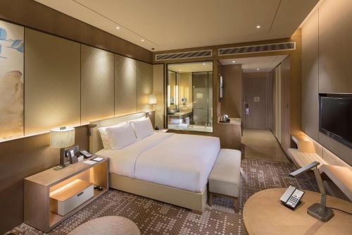 a hotel room with a bed and a television at DoubleTree By Hilton Xiamen-Haicang in Xiamen