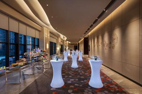 a row of white tables in a hotel lobby at DoubleTree By Hilton Xiamen-Haicang in Xiamen