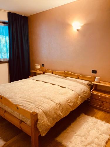 a bedroom with a bed and a window at Appartamento El Feudo in Tesero