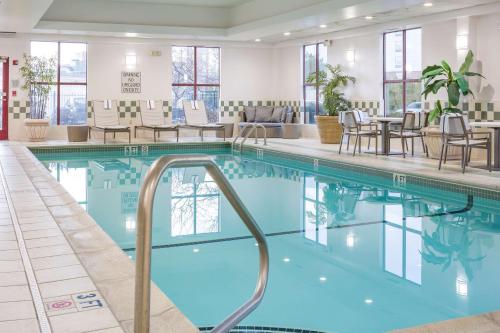 a pool with chairs and tables in a hotel lobby at DoubleTree by Hilton Boston Logan Airport Chelsea in Chelsea