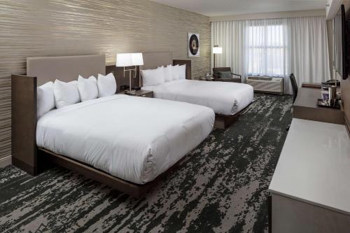 a hotel room with two beds and a desk at DoubleTree by Hilton Boston Logan Airport Chelsea in Chelsea