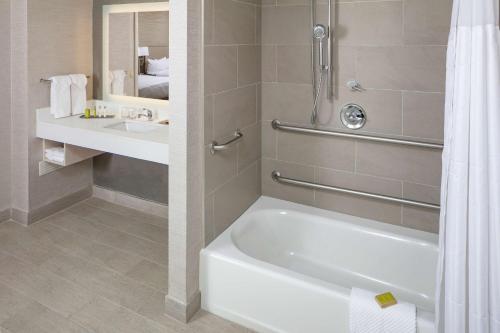 La salle de bains est pourvue d'une baignoire et d'un lavabo. dans l'établissement DoubleTree by Hilton Boston Logan Airport Chelsea, à Chelsea