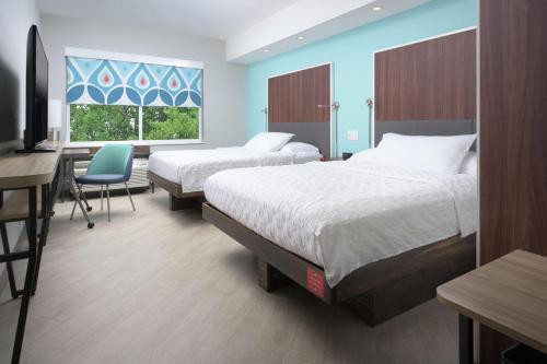 a hotel room with two beds and a desk and a window at Tru By Hilton McDonough in McDonough