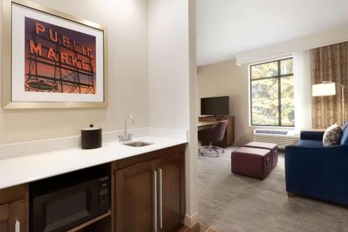 a kitchen with a sink and a living room at Hampton Inn & Suites Seattle/Renton, Wa in Renton