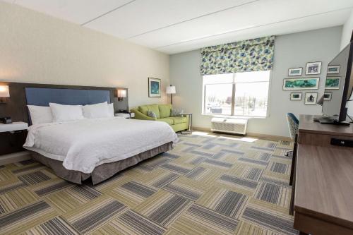 Hampton Inn & Suites Syracuse North Airport Area في North Syracuse: غرفة في الفندق مع سرير ومكتب