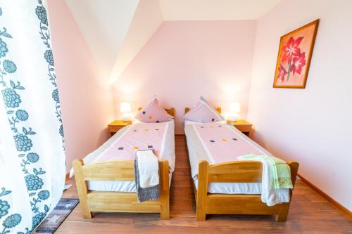 2 camas individuales en una habitación pequeña en una casa en Miodowe Łoże, en Woźnice