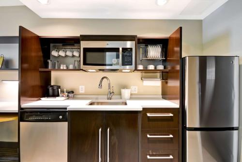 a kitchen with a sink and a refrigerator at Home2 Suites By Hilton Charles Town in Charles Town