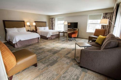 Habitación de hotel con 2 camas y sofá en Hampton Inn & Suites Manchester, Vt en Manchester