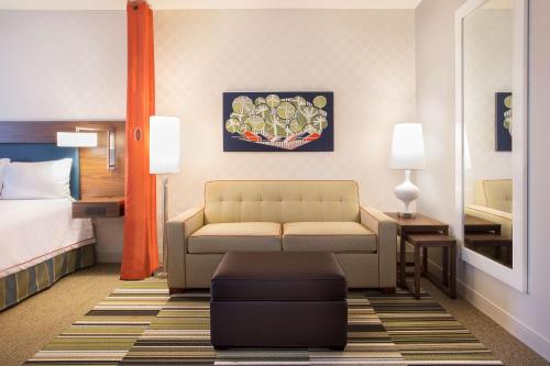 a hotel room with a couch and a bed at Home2 Suites By Hilton Oxford in Oxford