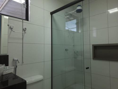 a bathroom with a shower with a glass door at Aiezza Hotel in Barcarena