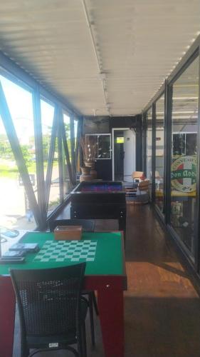 a room with a green table and chairs and windows at Aiezza Hotel in Barcarena
