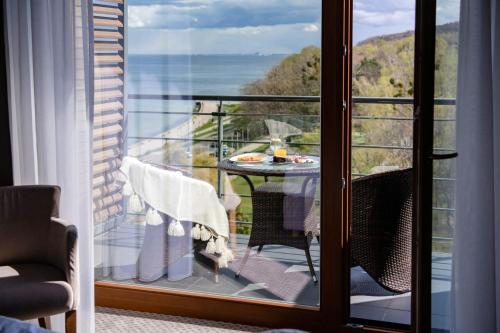 a balcony with a table and a view of the ocean at Hotel Różany Gaj - Destigo Hotels in Gdynia