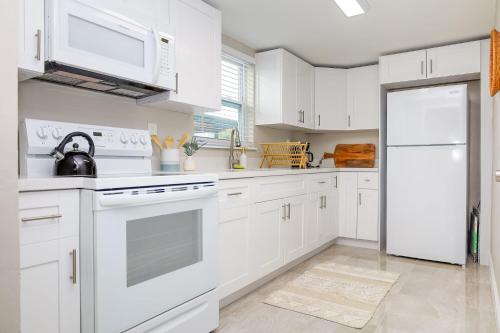 a kitchen with white cabinets and a white refrigerator at La Vie Boheme 1 - Relaxing Retreat w Parking in Miami