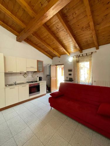 sala de estar con sofá rojo en la cocina en Appartamento tranquillo a due passi dal centro, en Vigevano