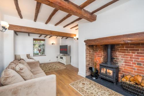 a living room with a brick wall and a fireplace at Bard's Cottage in Alcester