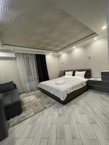 um quarto com uma cama grande e um sofá em SM Apartment em Yerevan