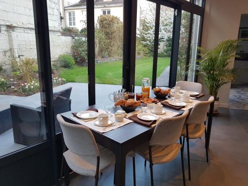 - une table avec de la nourriture dans une chambre avec des fenêtres dans l'établissement Couette et café Saumur, à Saumur