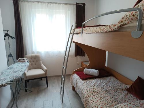 a bedroom with two bunk beds and a chair at Dubrovnik Apartment Nepe in Dubrovnik