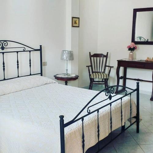 um quarto com uma cama, uma mesa e uma cadeira em Affitto camera il corbezzolo em Palmas Arborea