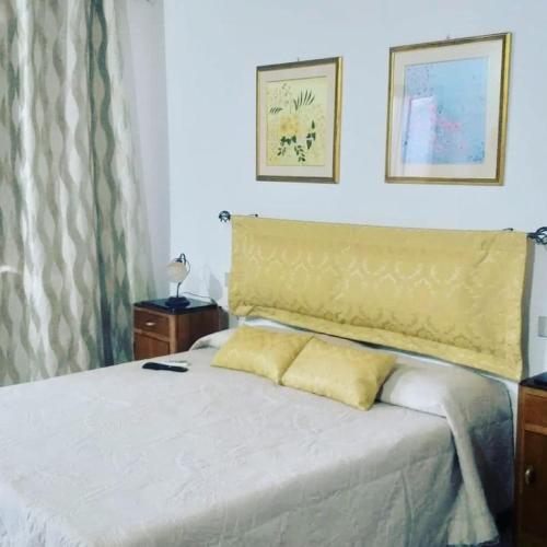um quarto com uma cama com uma cabeceira amarela em Affitto camera il corbezzolo em Palmas Arborea