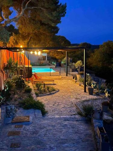 une arrière-cour avec une piscine la nuit dans l'établissement Sous le « Figuier », à Cornillon-Confoux