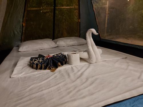 a bed with a swan and toilet paper on it at New Village Lodge in Oslob
