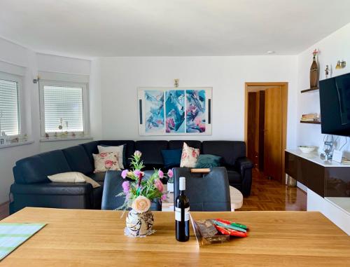ein Wohnzimmer mit einem blauen Sofa und einem Tisch in der Unterkunft Apartment Mandarina in Dugi Rat