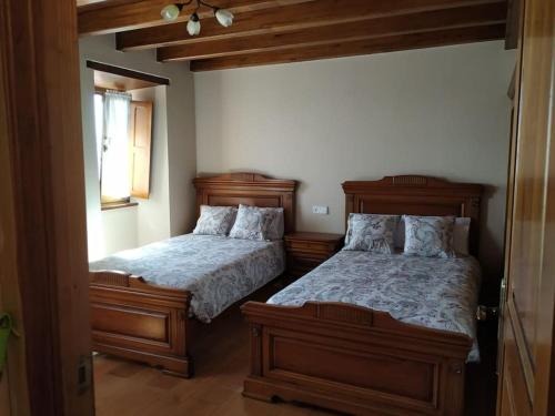 a bedroom with two beds and a window at Casa barrio el Reloj - Lastres in Lastres