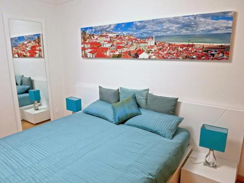 a bedroom with a blue bed and a painting on the wall at Finest Rentals - Expo Riverside in Lisbon