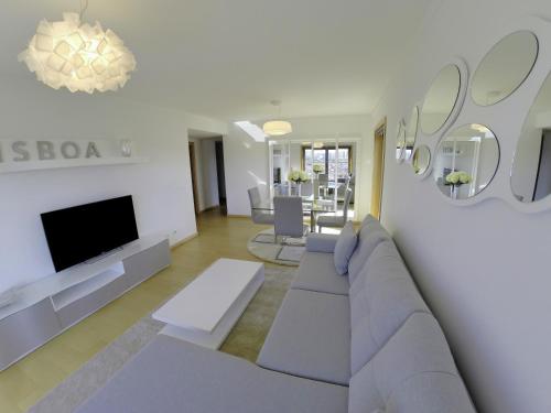 a living room with a couch and a tv at Finest Rentals - Expo Riverside in Lisbon