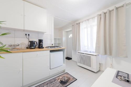 een witte keuken met witte kasten en een raam bij Barbarosa Sweet Dream 1 in Boedapest