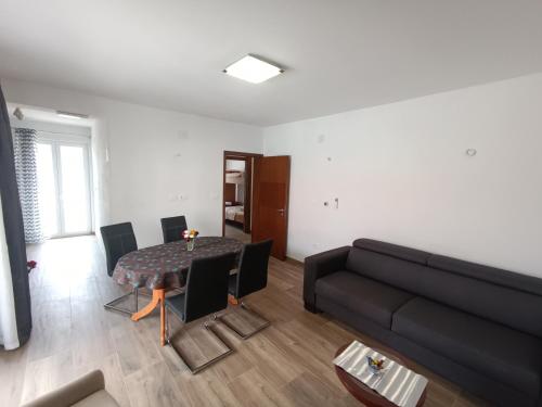 a living room with a black couch and a table at Dubrovnik Apartment Nepe in Dubrovnik